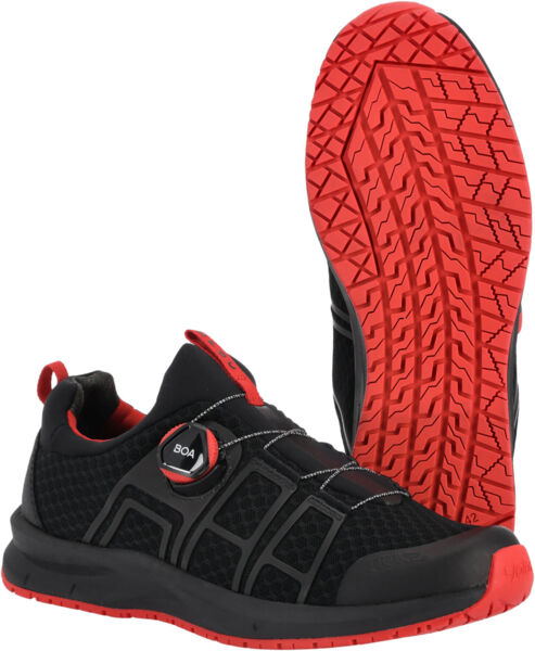 The image shows a black sports shoe with red accents. The sole features a distinctive, grippy pattern. A special lacing device is visible, which makes putting on the shoe easier.