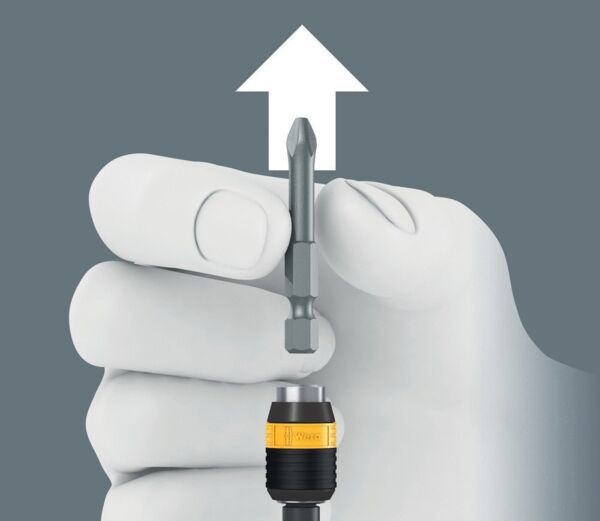 A gray background, on which a hand is holding a screwdriver with a magnetic attachment. Above the hand, an arrow points upward, indicating an action or direction.