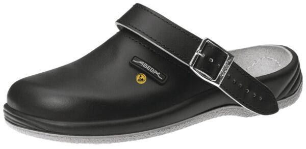 The image shows a black clog with a wide strap and a buckle. The sole is light gray and the shoe has a solid, closed form.