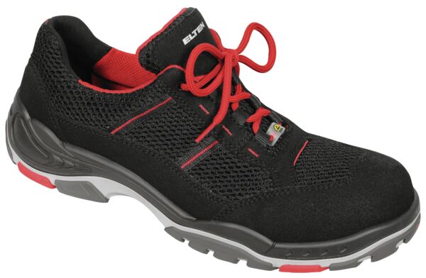 The shoe is black with red accents. It has a breathable mesh upper and laces. The sole is grippy, with a gray and red rubber coating.