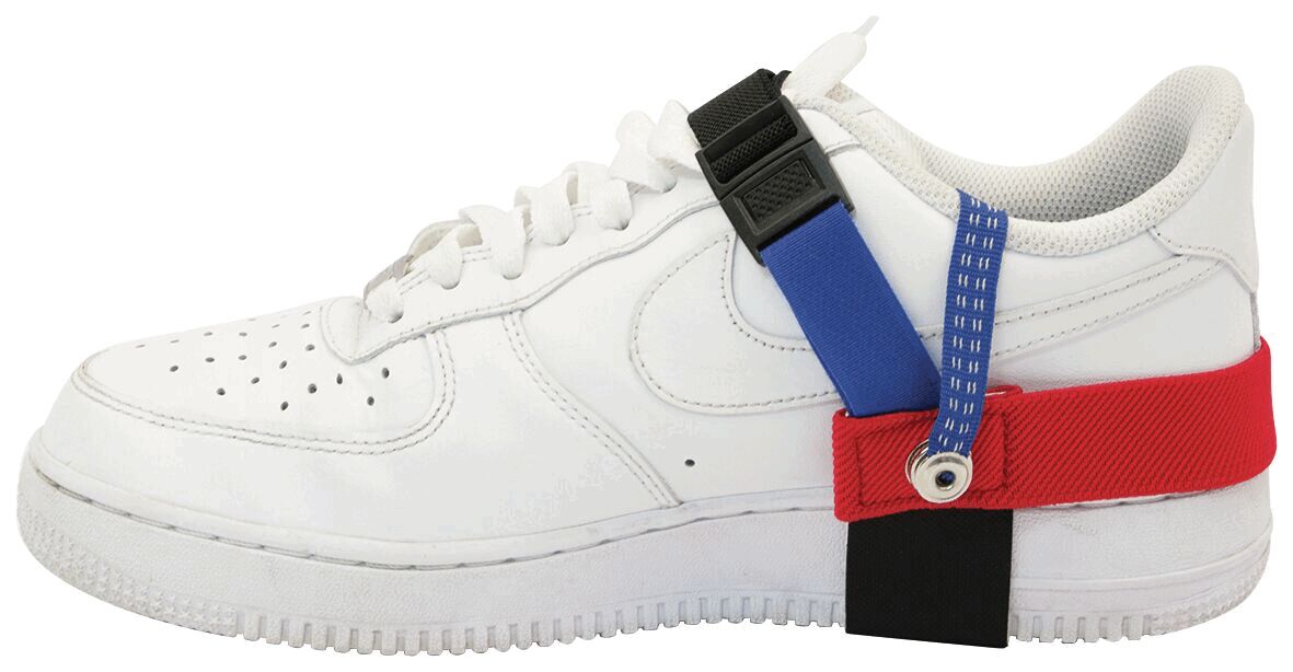 The image shows a white sneaker with various colored straps: red, blue, and black, attached to the side of the shoe. The shoe has a classic sneaker shape with laces.