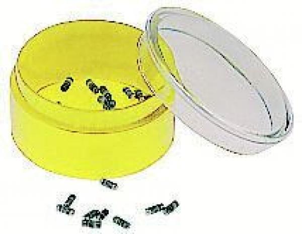 The image shows a yellow, round box with a transparent lid. The box is open and contains small, black objects that are scattered.