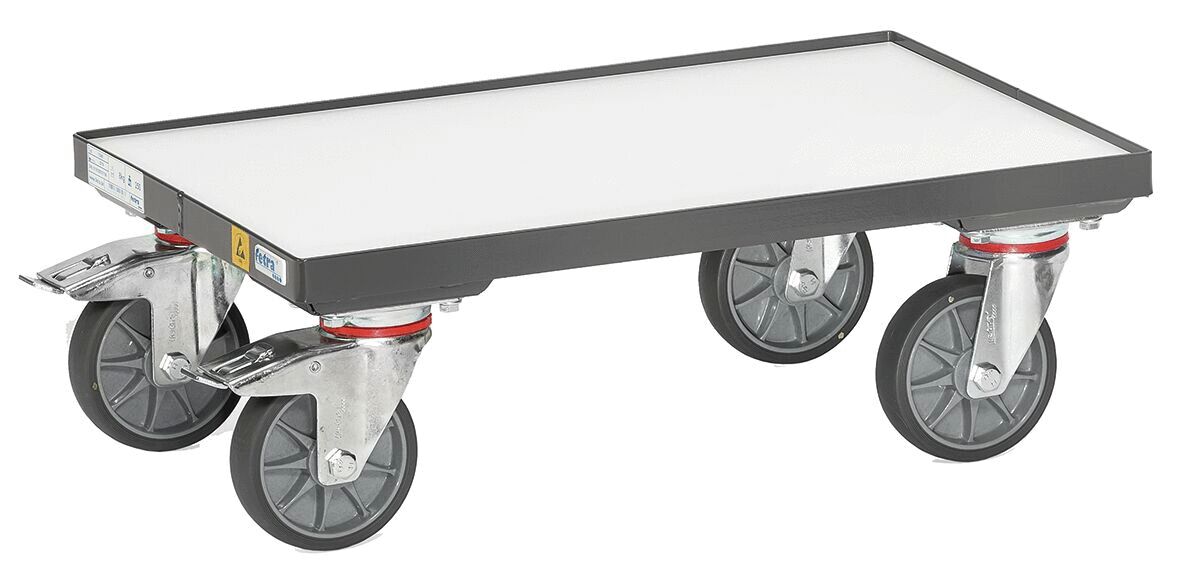 The image shows a flat transport platform with four large wheels. The surface is smooth and rectangular, the material appears sturdy and robust. The wheels are swivel.