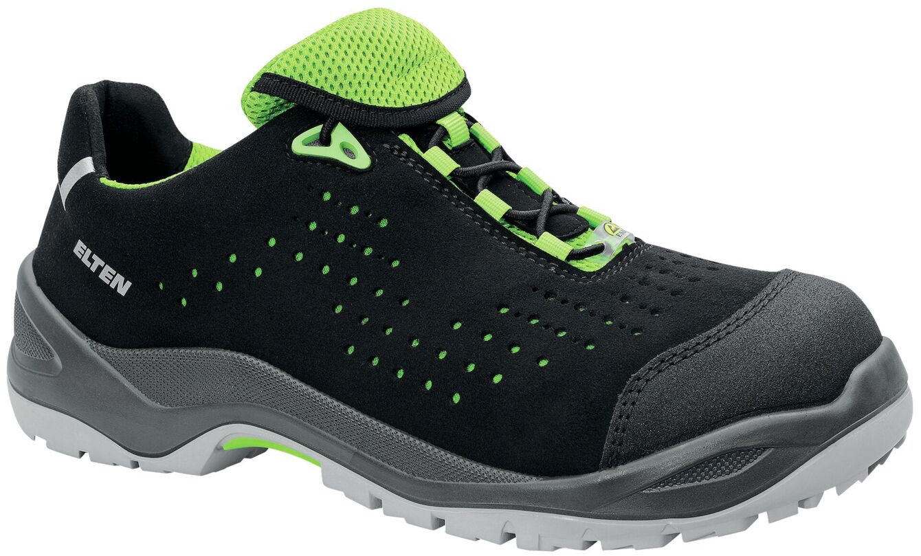 The shoe is a low, black work shoe with green accents. It has a breathable mesh upper and a non-slip rubber sole, ideal for safe walking.