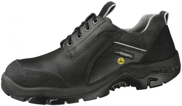 The shoe is black with a smooth, sturdy surface. It has laces and a reinforced toe cap. The sole is textured for better grip and stability. The shape is sporty and ergonomic.