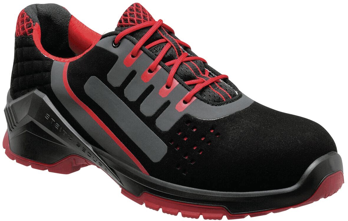 The shoe is a sporty safety shoe in black with red accents. It has a sturdy sole, padded collar, and laces. The design is modern and functional.