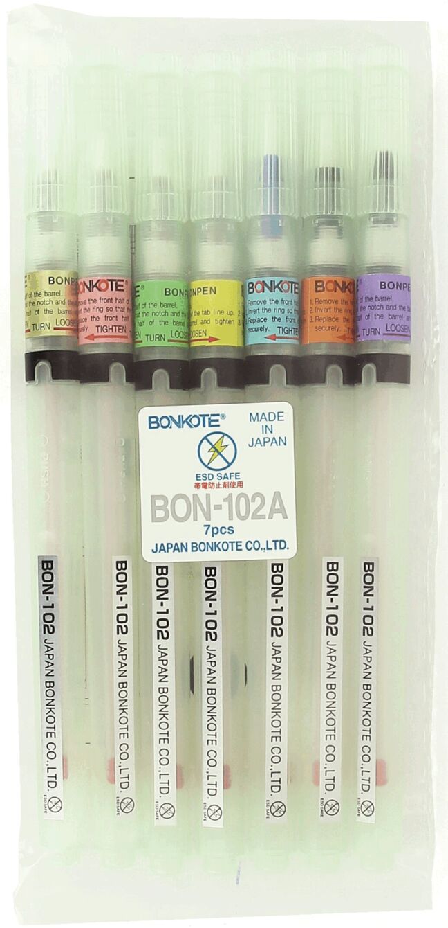 The image shows a transparent case with seven pens. Each pen has a differently colored cap visible at the top. The pens are labeled and the label is located in the middle of the case.