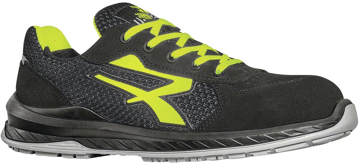 The shoe is a modern sports shoe in black with bright yellow accents. It has a flat sole, laces, and a breathable upper made of textile and synthetic.