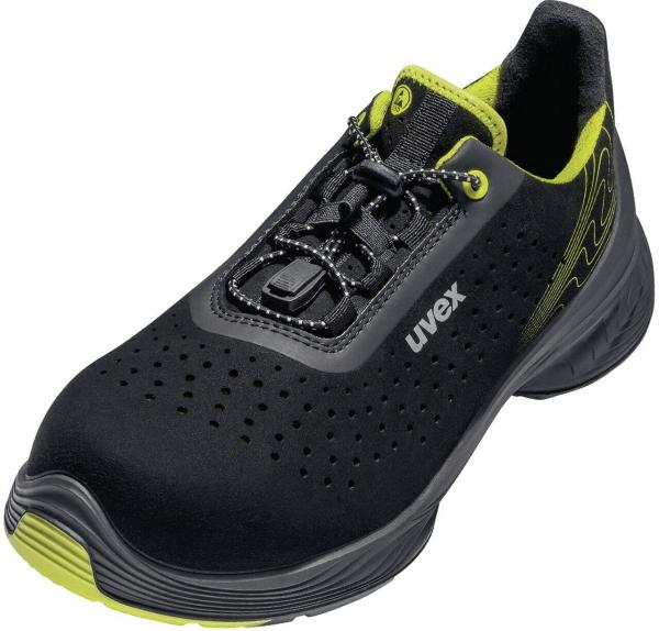 The shoe is black with yellow accents. It has a breathable surface with many small holes and a modern lacing system. The sole is non-slip and flexible.