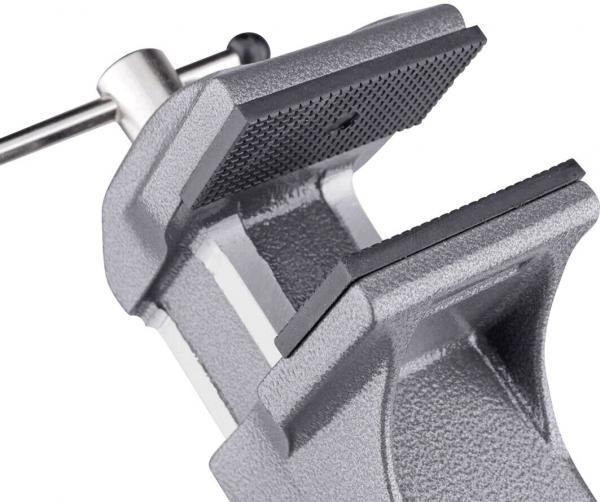 The image shows a gray metal vise. It has two parallel jaws that can be opened and closed to hold objects in place. An adjustment screw is visible.