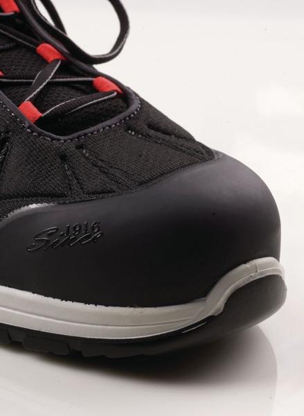 The image shows the front of a black shoe with a soft, rounded toe area. Red laces thread through the upper, which is made of a durable fabric.