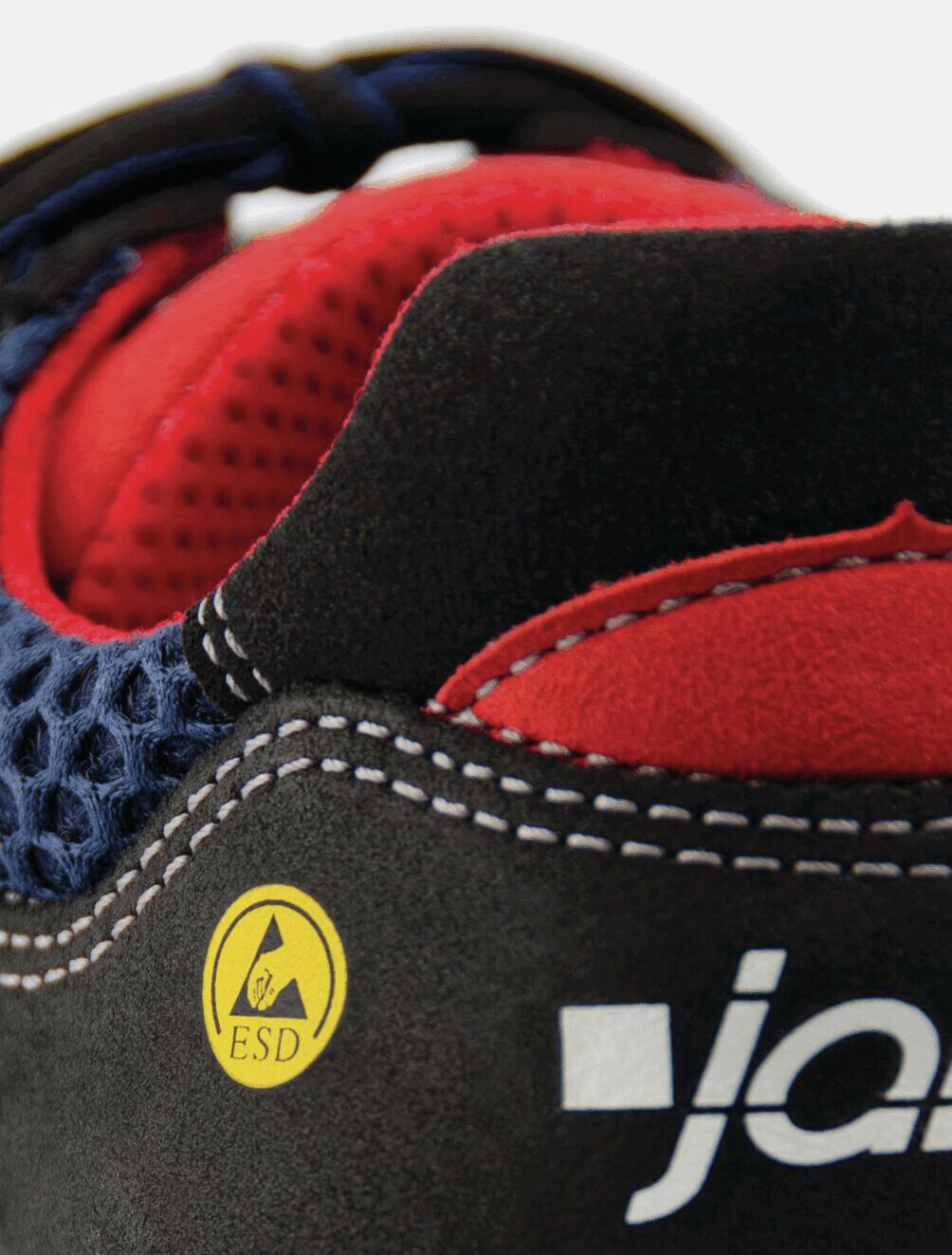 The image shows a part of a shoe with a combination of black, red, and blue material. There is a yellow ESD symbol and white stitching along the edge.