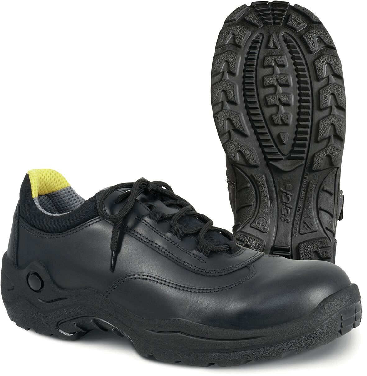 The image shows a black shoe with laces. It has a sturdy, rubberized sole with a non-slip pattern. The interior is light gray, with a yellow accent at the heel.