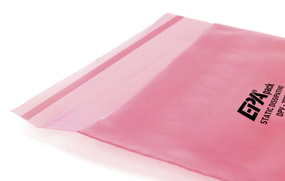 Das Bild zeigt einen pinken, transparenten Beutel mit einem Klebestreifen oben. Auf der Vorderseite steht ?ESD Pack STATIC DISSIPATIVE? in schwarzer Schrift. Der Beutel dient zum Schutz empfindlicher Materialien.