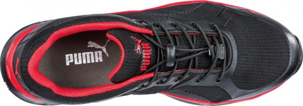 The shoe is black with red accents. It has laces on top and a breathable mesh material. The insole features the Puma logo. It appears sporty and modern.