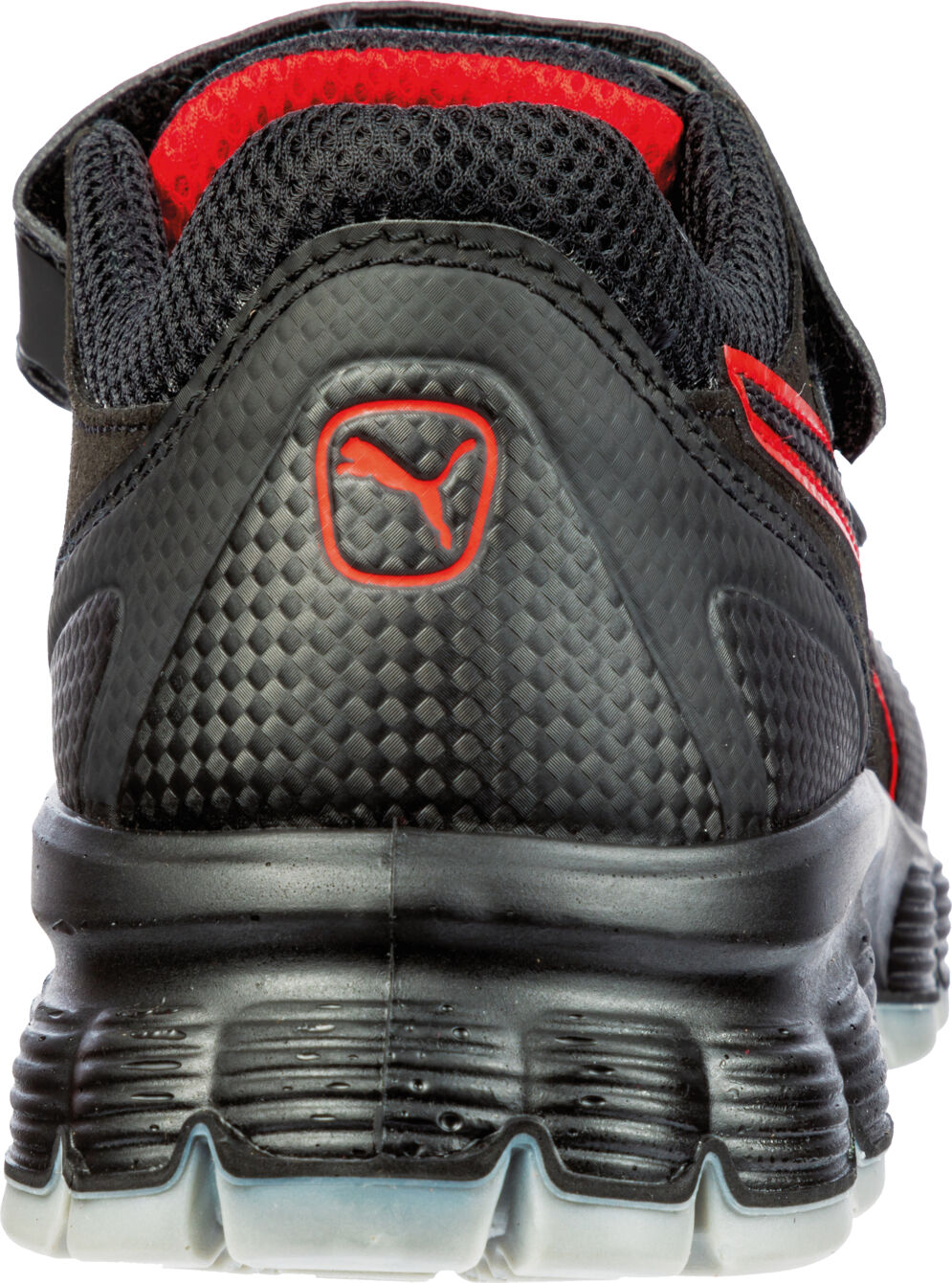 The image shows the rear view of a black sports shoe with red accents. The sole is thick and textured, the upper material has a coarse, non-slip texture. A Puma logo is visible.