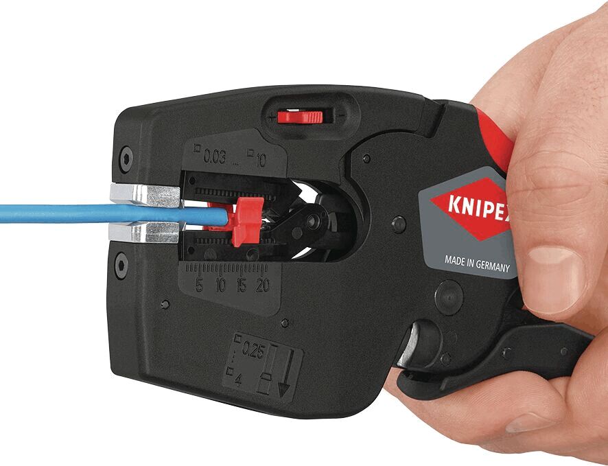 The image shows a wire cutter in a hand. The cutting mechanism is black, with red and grey details. A blue wire is inserted into the pliers, ready to be cut.