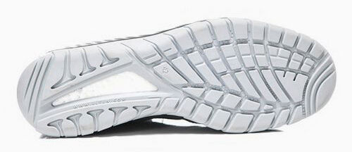 The image shows the sole of a sports shoe. It is made of rubber, has a wavy pattern with multiple grooves and indentations for better grip. The color is predominantly light.