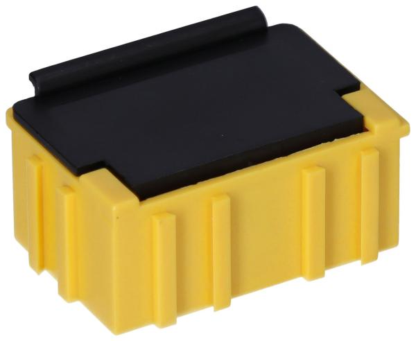 The image shows a rectangular, yellow plug or a box with a black cover on top. The sides are textured with vertical grooves. The shape is compact and sturdy.