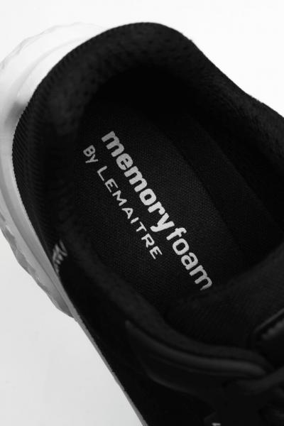 The image shows the inside of a black shoe with a soft, padded insert. On the insert, the text "memory foam by Lemaître" is written in white font.