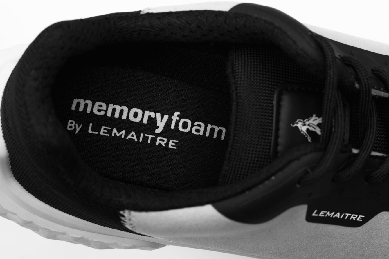 The image displays the insole of a sports shoe. The sole is labeled with "memory foam," indicating exceptional comfort. The colors are black and white, simple and modern.