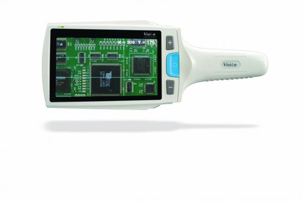 The image shows a handheld digital magnification device with a screen displaying a green circuit diagram. It has a white handle and buttons for operation.