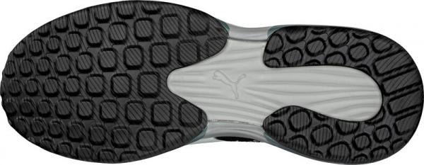 The image shows the underside of a sports shoe. The sole features a textured pattern with protruding, round and rectangular dots, and a logo is visible in the center.