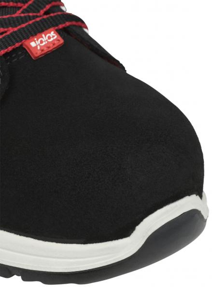 The image displays the front view of a black sports shoe with a round, white sole. The laces are red and black, and the fabric appears soft and durable.