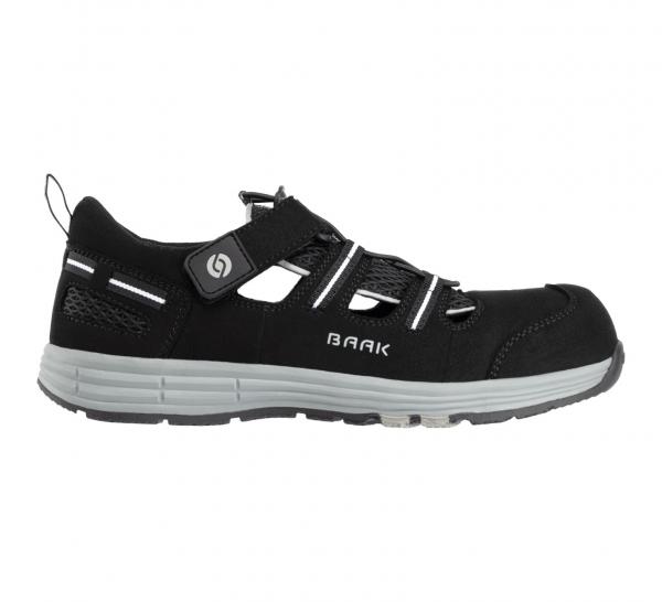 The image shows a black shoe with a sporty shape. It has elastic laces and a Velcro fastener. The sole is light gray and designed for good grip.