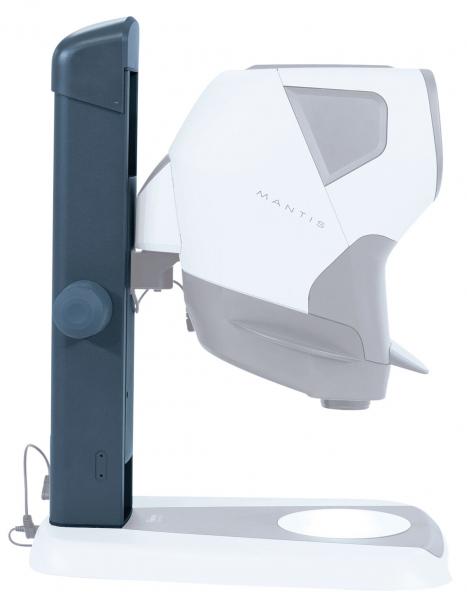 The image shows an eye examination device. It has a curved, white surface and is mounted on a stable base. On the side, there is a large, round button.