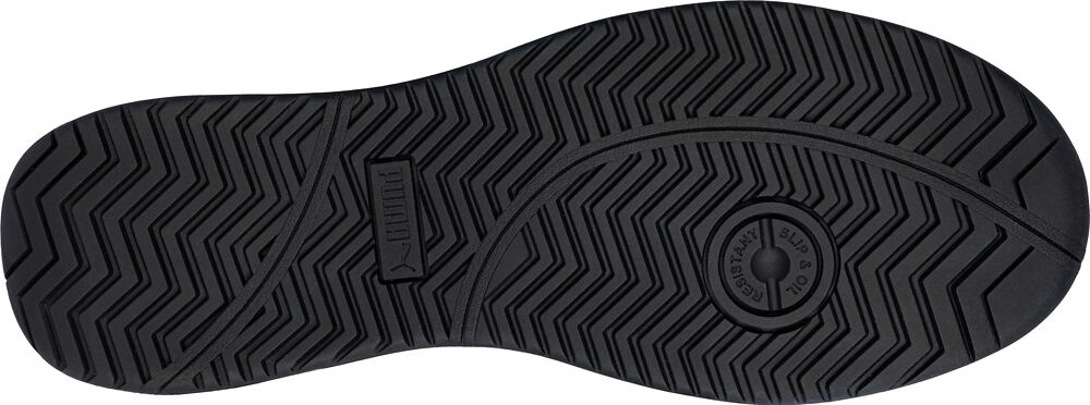 The image shows the underside of a black shoe sole. It has a grooved tread with various patterns for better grip. The sole is flat and round.