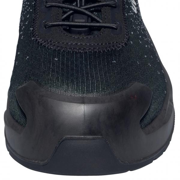 The image shows the front view of a sports shoe. The shoe is predominantly black with a textured upper and a sturdy, rounded sole. The laces are visible.