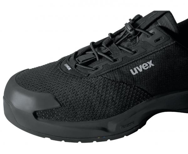 The picture shows a black work or sports shoe. It features a breathable mesh upper and a sturdy rubber cap at the tip. The laces ensure a secure fit.