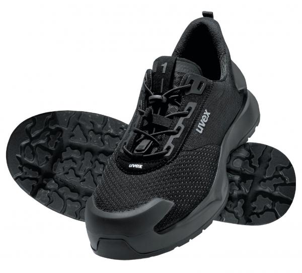 The image shows a black shoe with a textured sole. The shoe has laces and a breathable surface. It appears sporty and sturdy.