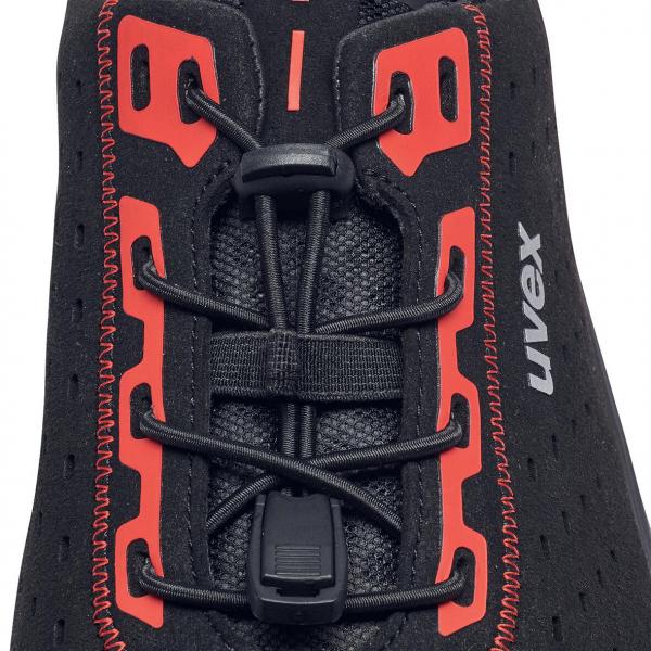 The image shows the upper part of a black shoe with red laces. The laces pass through special, red eyelets that are clearly visible. The brand name "Uvex" is embossed.