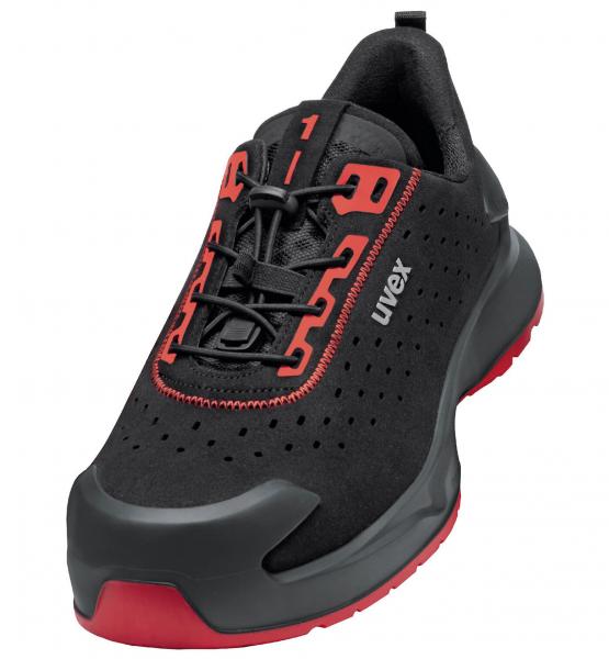 The shoe is sporty, predominantly black with red accents. It features modern lacing and a rubberized sole that provides comfort and stability. Perforations ensure breathability.