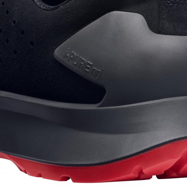 The image shows a shoe in black with a smooth, gray upper and a red sole. The word "Supreme" is embossed on the gray area.