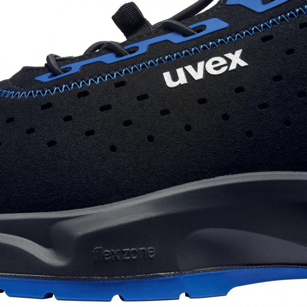 The image shows a black sports or casual shoe with blue accents. The shoe has a modern, breathable surface with small holes and a flexible sole.