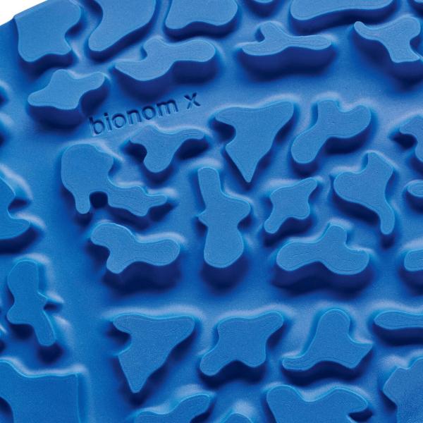 The image displays a structured, blue surface with irregular, raised patterns. The shapes resemble abstract contours and vary in size and form, creating a tactile texture.