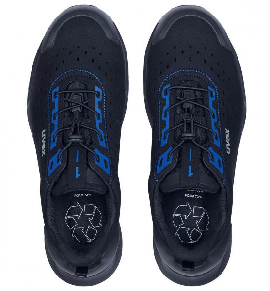 The image shows a pair of black sports shoes with blue accents. The laces are central and the sole is robust. The shoes appear modern and functional.