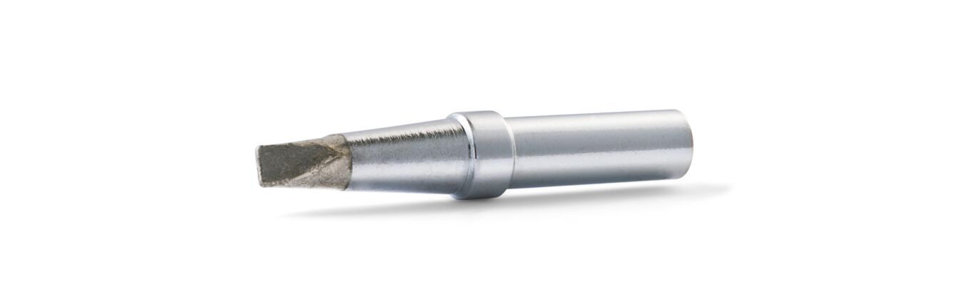 The image shows a narrow, silver screwdriver with a flat end. The handle is smooth and cylindrical, while the tip is slightly beveled to turn screws.