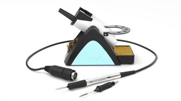 The image shows a soldering iron with a stand. The stand has a blue area and contains sponge material. Next to the soldering iron are two soldering iron tips and a cable.