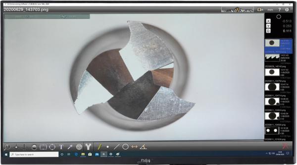 The image shows a close-up of a rotating, cutting tool with multiple metal edges. It is circular in design, against a bright background.