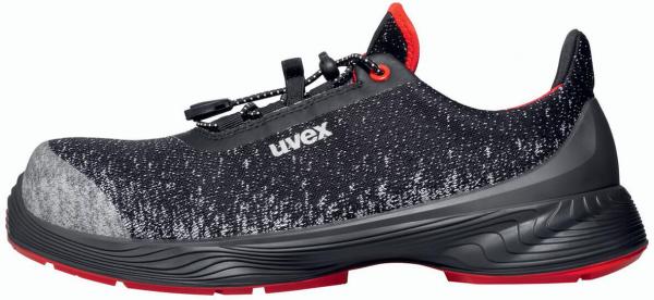 The shoe is a sporty safety sneaker in black with gray and red accents. It has a breathable surface and a non-slip sole for secure grip.