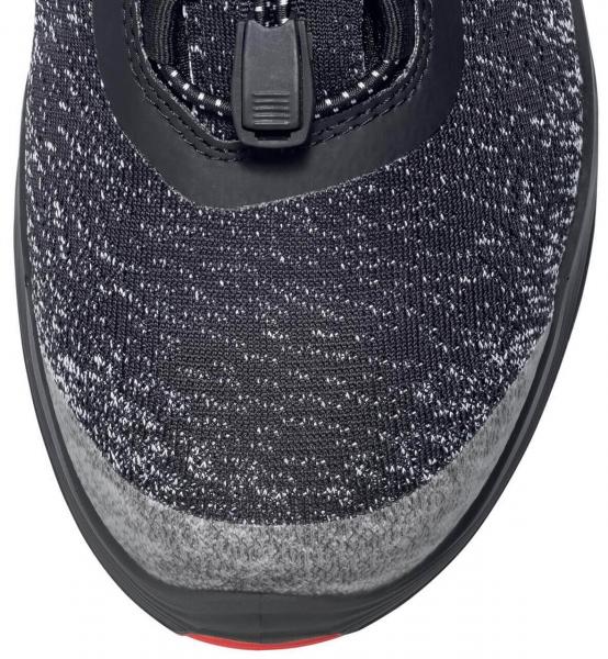 The image displays the top view of a sports shoe. The shoe features a predominantly black, textured upper with gray and white accents. The toe is rounded and has a non-slip sole. A black quick-lacing system is visible.