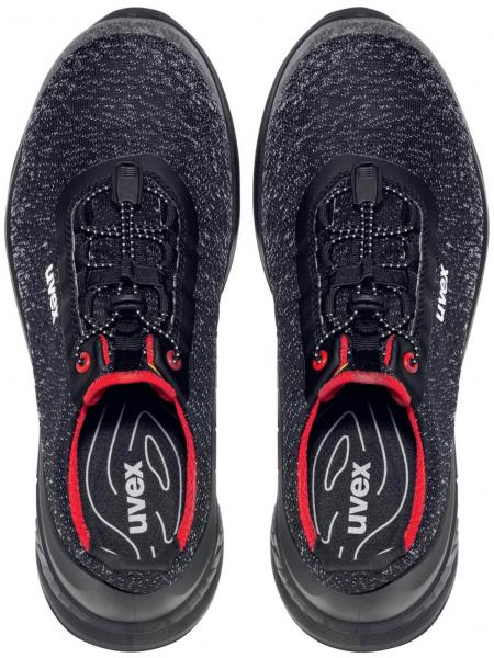 Here are two black athletic shoes with a smooth upper. They have a round toe cap, a comfortable shaft, and black laces with red accents.