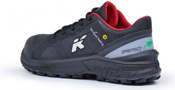 The shoe is a black sneaker with red accents. It has a sporty design, a reinforced profile, and a non-slip sole. On the side are logos and notes on the technology.