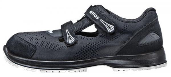 The shoe is black, with a breathable upper made of perforated material. It has a wide Velcro strap and a grippy, light sole. Ideal for sports or leisure activities.