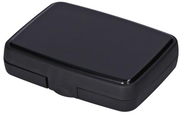 The image shows a rectangular, matte, black box with rounded edges. It has a smooth surface and a flap that likely protects contents inside.