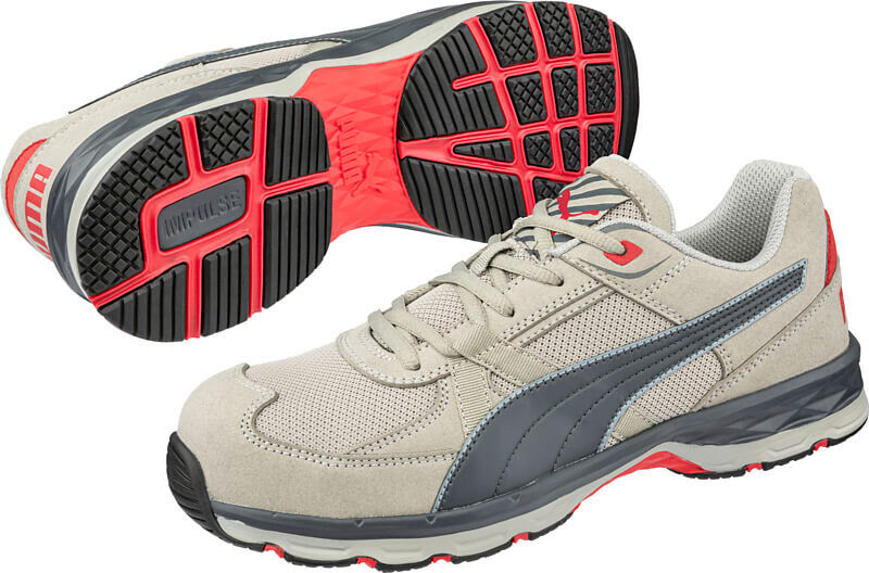 The image shows a pair of sporty shoes in beige with gray and red accents. The sole has a grippy, textured pattern for good traction. They appear sturdy and versatile.